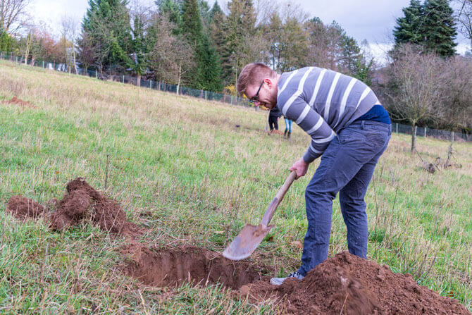 Foto von Eric Gross der gerade ein Loch gräbt um einen Baum einzupflanzen
