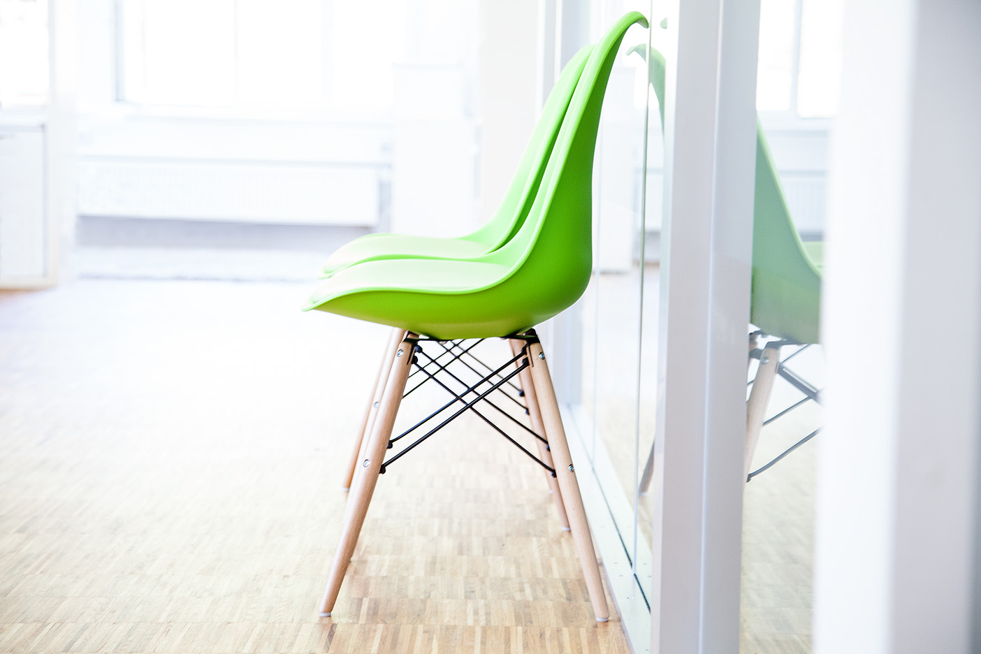 Ein grüner Stuhl an einer Glaswand