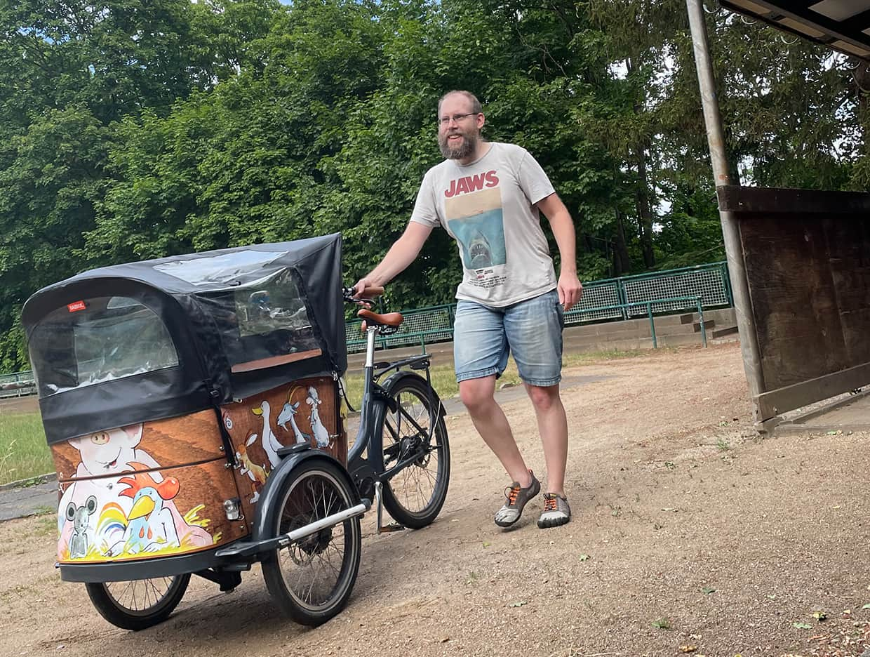 Foto von Daniel Schultheis der vor einem Fahrrad mit 3 Rädern steht