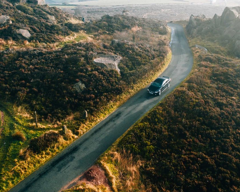 Aus der Vogelperspektive: Ein Auto fährt eine Straße entlang