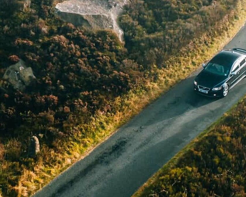 Aus der Vogelperspektive: Ein Auto fährt eine Straße entlang